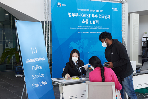 행사부스에서 외국인 가족에게 응대중인 직원 사진